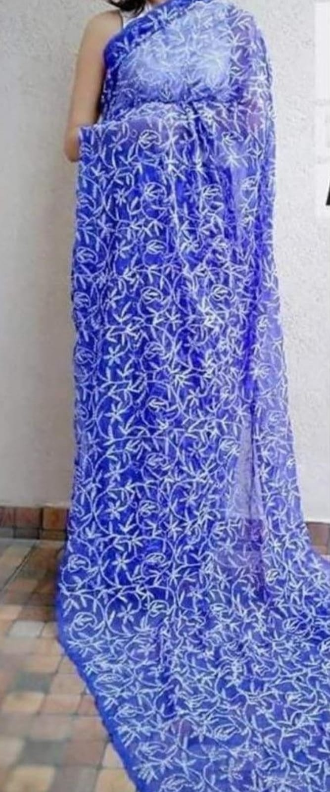 A woman showcasing a red and white georgette saree with Lucknow Chikankari and Tepchi hand embroidery work all over.