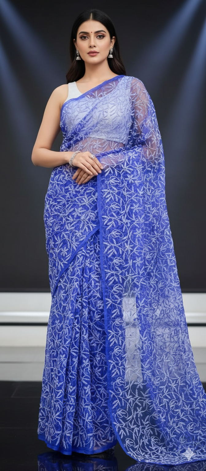Woman wearing a blue saree with white floral patterns on a dark background